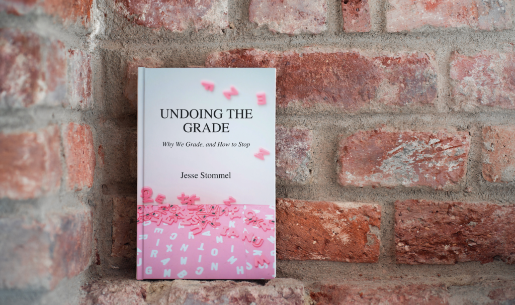 Cover of the book Undoing the Grade by Jesse Stommel in front of a brick wall.