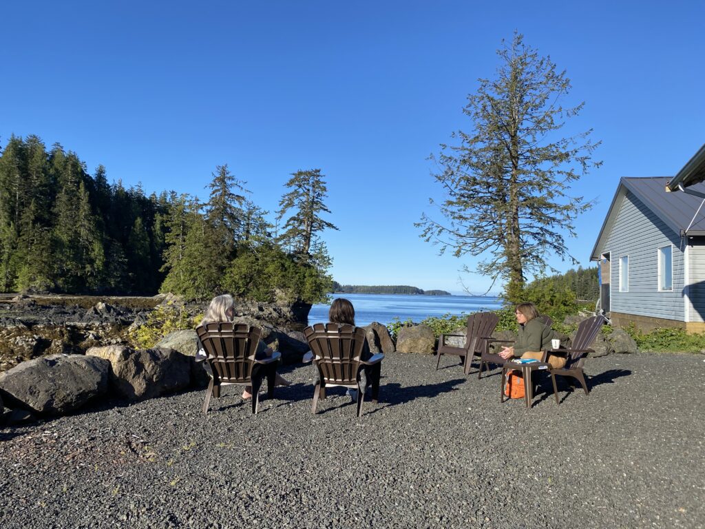 Student sitting on chairs outdoors by the ocean