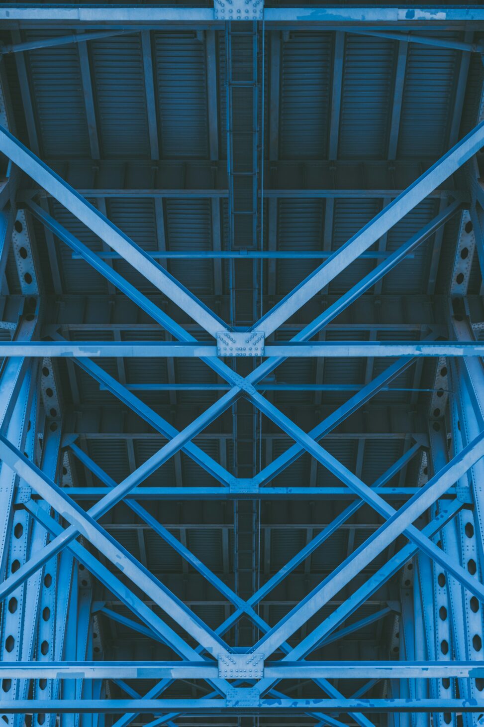 Blue steel beams under a bridge