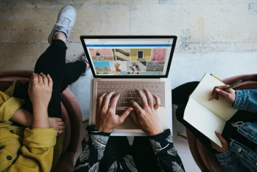 Bird's eye view of three people working at a laptop together.